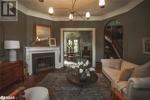 Living room featuring dark hardwood / wood-style flooring and crown molding - 42 Burton Avenue, Barrie, ON - Indoor Photo Showing Living Room With Fireplace