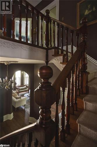 Stairway with hardwood / wood-style floors and an inviting chandelier - 42 Burton Avenue, Barrie, ON - Indoor Photo Showing Other Room