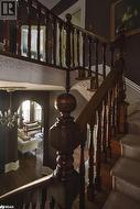 Stairway with hardwood / wood-style floors and an inviting chandelier - 