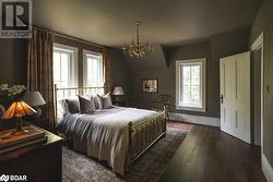 Bedroom featuring dark hardwood / wood-style flooring and a notable chandelier - 