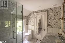 Bathroom featuring vanity, tile patterned floors, toilet, and vaulted ceiling - 