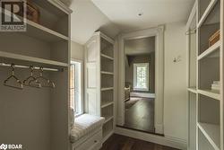 Spacious closet with dark hardwood / wood-style flooring - 