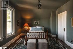 Bedroom featuring dark wood-type flooring, multiple windows, and lofted ceiling - 