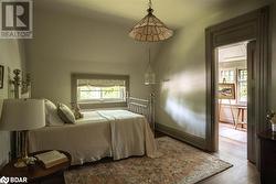 Bedroom featuring hardwood / wood-style flooring and multiple windows - 