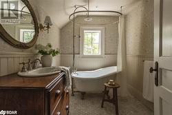 Bathroom featuring a tub, vanity, and lofted ceiling - 