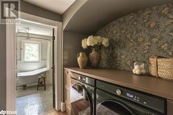 Laundry room featuring washing machine and dryer and light wood-type flooring - 