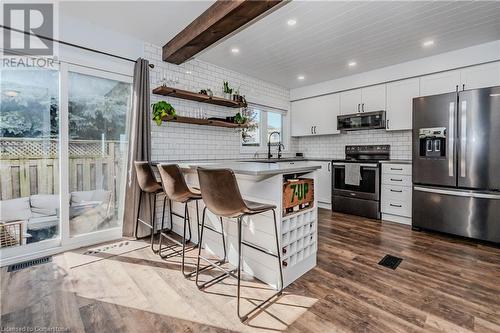 Kitchen featuring white cabinets, hardwood / wood-style flooring, a kitchen bar, and appliances with stainless steel finishes - 230 Blackhorne Drive Unit# 19, Kitchener, ON - Indoor Photo Showing Kitchen With Upgraded Kitchen