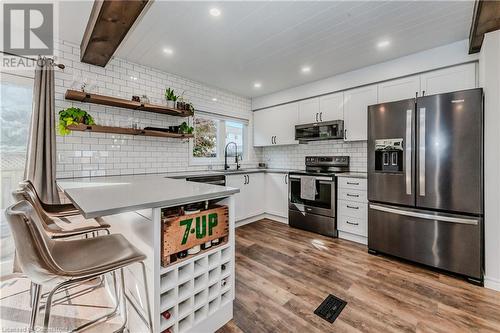 Kitchen with stainless steel appliances, wood-type flooring, white cabinetry, and tasteful backsplash - 230 Blackhorne Drive Unit# 19, Kitchener, ON - Indoor Photo Showing Kitchen With Upgraded Kitchen