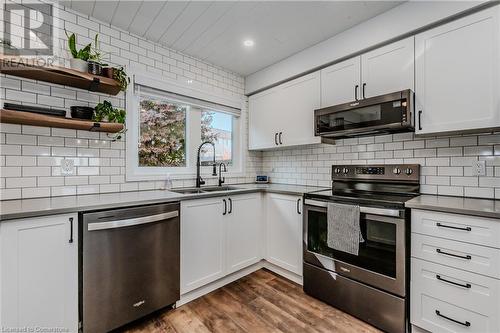 Kitchen with tasteful backsplash, appliances with stainless steel finishes, dark hardwood / wood-style flooring, sink, and white cabinets - 230 Blackhorne Drive Unit# 19, Kitchener, ON - Indoor Photo Showing Kitchen With Double Sink With Upgraded Kitchen