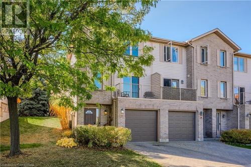 Multi unit property featuring a garage, a front lawn, and a balcony - 230 Blackhorne Drive Unit# 19, Kitchener, ON - Outdoor With Facade