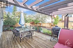 Step outside to a beautifully private, fenced backyard that’s perfect for relaxation or entertaining, featuring a large deck, gardens, and a semi-in-ground heated saltwater "Aquabois" pool. - 