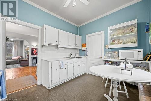 Kitchen with sink, ceiling fan, backsplash, white cabinets, and dark wood-type flooring - 55 Edgehill Drive, Guelph, ON - Indoor