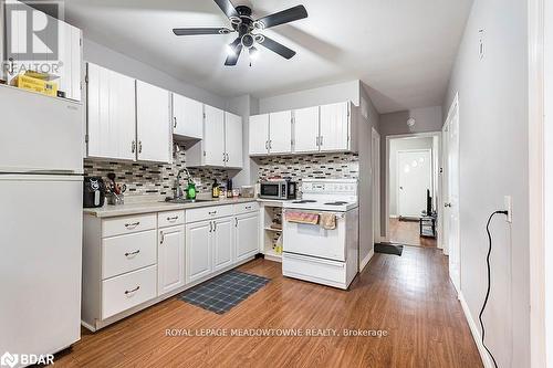 Kitchen with white cabinets, white appliances, sink, and light wood-type flooring - 77 Province Street N, Hamilton, ON - Indoor Photo Showing Kitchen