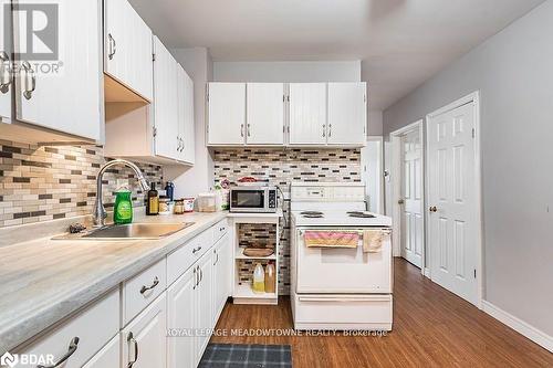 Kitchen featuring white cabinets, dark wood-type flooring, sink, and electric stove - 77 Province Street N, Hamilton, ON - Indoor Photo Showing Kitchen