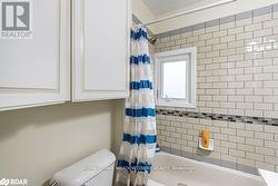 Bathroom featuring toilet and shower / bathtub combination with curtain - 