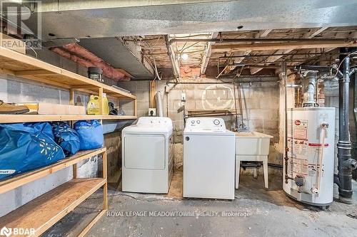 Basement with washing machine and dryer, gas water heater, and sink - 77 Province Street N, Hamilton, ON - Indoor Photo Showing Laundry Room