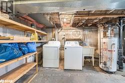 Basement with washing machine and dryer, gas water heater, and sink - 