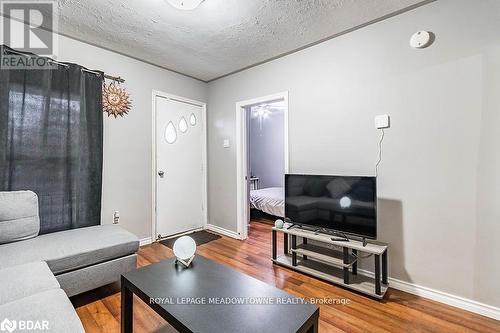 Living room featuring a textured ceiling and hardwood / wood-style flooring - 77 Province Street N, Hamilton, ON - Indoor Photo Showing Living Room