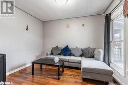 Living room featuring a textured ceiling and hardwood / wood-style flooring - 