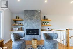 Living area with a tile fireplace and light wood-type flooring - 