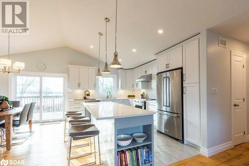 Kitchen with white cabinetry, vaulted ceiling, light hardwood / wood-style floors, and stainless steel appliances - 1647 Lakeside Drive, Hillier, ON - Indoor Photo Showing Kitchen With Upgraded Kitchen