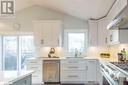 Kitchen featuring white cabinets, appliances with stainless steel finishes, exhaust hood, and lofted ceiling - 1647 Lakeside Drive, Hillier, ON - Indoor Photo Showing Kitchen With Upgraded Kitchen