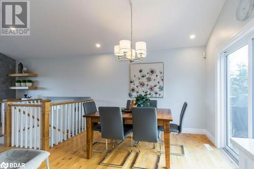 Dining space with a chandelier, light hardwood / wood-style flooring, and vaulted ceiling - 1647 Lakeside Drive, Hillier, ON - Indoor Photo Showing Dining Room