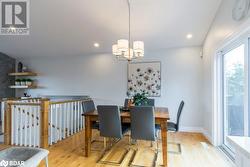 Dining space with a chandelier, light hardwood / wood-style flooring, and vaulted ceiling - 