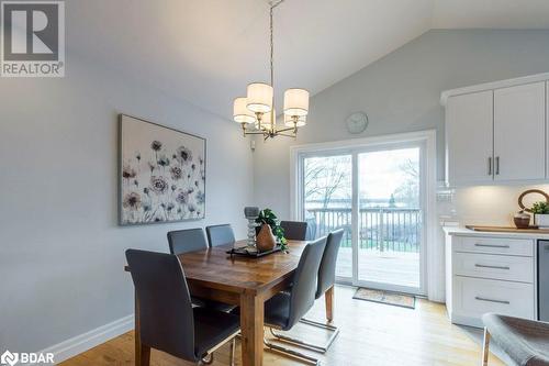 Dining space with light wood-type flooring, vaulted ceiling, and an inviting chandelier - 1647 Lakeside Drive, Hillier, ON - Indoor Photo Showing Dining Room