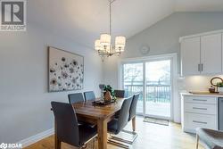 Dining space with light wood-type flooring, vaulted ceiling, and an inviting chandelier - 