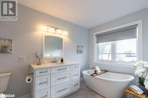 Bathroom with toilet, vanity, a bath, and tile patterned floors - 1647 Lakeside Drive, Hillier, ON - Indoor Photo Showing Bathroom