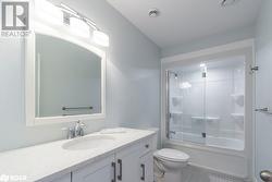 Full bathroom with bath / shower combo with glass door, vanity, toilet, and tile patterned floors - 