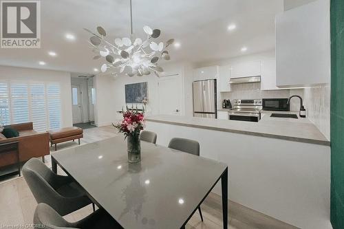 Dining room featuring a chandelier, sink, and light hardwood / wood-style flooring - 1701 Lampman Avenue Unit# 601, Burlington, ON - Indoor Photo Showing Dining Room