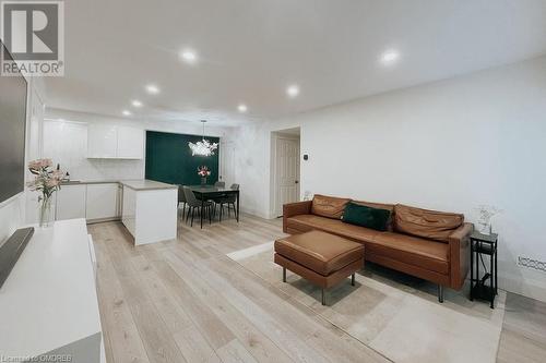 Living room featuring light hardwood / wood-style floors and a chandelier - 1701 Lampman Avenue Unit# 601, Burlington, ON - Indoor