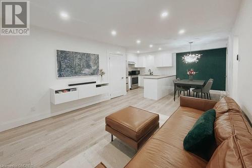 Living room featuring a chandelier, sink, and light hardwood / wood-style floors - 1701 Lampman Avenue Unit# 601, Burlington, ON - Indoor Photo Showing Living Room