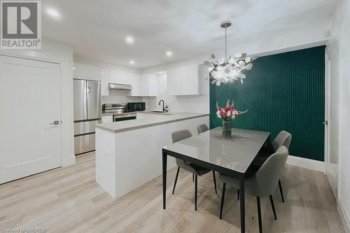 Dining room with light hardwood / wood-style flooring, a notable chandelier, and sink - 1701 Lampman Avenue Unit# 601, Burlington, ON - Indoor