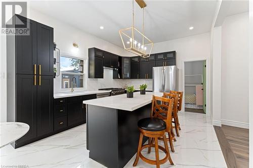 Kitchen featuring stainless steel appliances, sink, a breakfast bar area, a kitchen island, and pendant lighting - 50 Ontario Street, Brantford, ON - Indoor Photo Showing Kitchen With Upgraded Kitchen