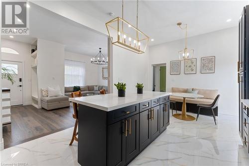 Kitchen featuring a kitchen bar, a kitchen island, pendant lighting, breakfast area, and light hardwood / wood-style flooring - 50 Ontario Street, Brantford, ON - Indoor