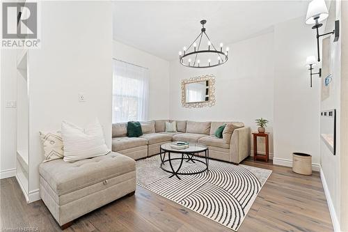 Living room with an inviting chandelier and dark hardwood / wood-style flooring - 50 Ontario Street, Brantford, ON - Indoor Photo Showing Living Room