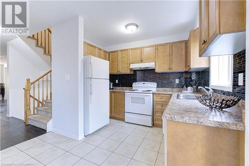 Kitchen with decorative backsplash, sink, white appliances, and light wood-type flooring - 151 Green Road S Unit# 26, Stoney Creek, ON - Indoor Photo Showing Kitchen