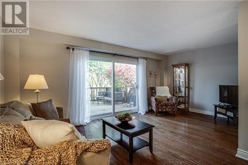 Living room,  hardwood flooring, sliding doors to private deck - 2301 Cavendish Drive Unit# 106, Burlington, ON - Indoor Photo Showing Living Room