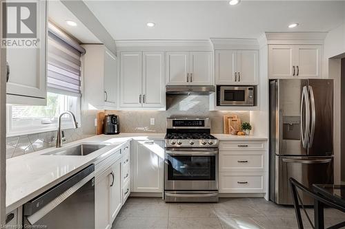 Kitchen with stainless steel appliances, light quartz counters, white cabinets, backsplash - 2301 Cavendish Drive Unit# 106, Burlington, ON - Indoor Photo Showing Kitchen With Stainless Steel Kitchen With Upgraded Kitchen