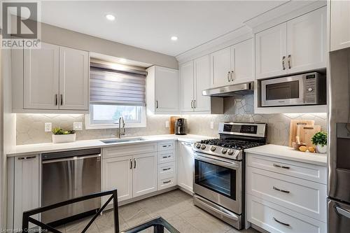 Kitchen with stainless steel appliances, light quartz counters, white cabinets, backsplash - 2301 Cavendish Drive Unit# 106, Burlington, ON - Indoor Photo Showing Kitchen With Stainless Steel Kitchen With Upgraded Kitchen