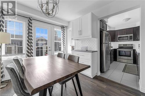 Dining space featuring dark wood-type flooring, a healthy amount of sunlight, and a notable chandelier - 143 Ridge Road Unit# 68, Cambridge, ON - Indoor