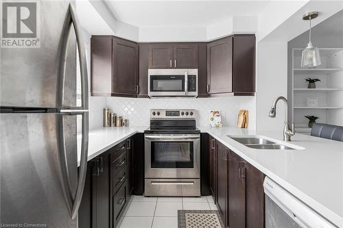 Kitchen with stainless steel appliances, light tile patterned flooring, sink, decorative light fixtures, and decorative backsplash - 143 Ridge Road Unit# 68, Cambridge, ON - Indoor Photo Showing Kitchen With Stainless Steel Kitchen With Double Sink With Upgraded Kitchen