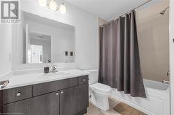 Full bathroom with vanity, shower / bathtub combination with curtain, and toilet - 