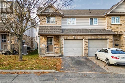 Multi unit property featuring central air condition unit and a garage - 169 Bismark Drive Unit# 32, Cambridge, ON - Outdoor With Facade