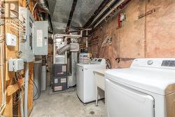 Laundry area with washing machine and clothes dryer and electric water heater - 