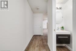 Hall featuring sink and light wood-type flooring - 