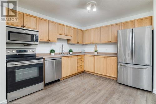 Kitchen with light brown cabinets, appliances with stainless steel finishes, sink, and light hardwood / wood-style flooring - 169 Bismark Drive Unit# 32, Cambridge, ON - Indoor Photo Showing Kitchen With Double Sink